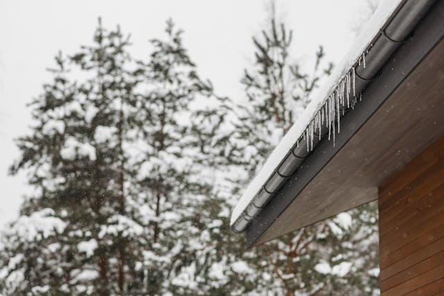 Gutter on a roof of a house clogged with snow and ice